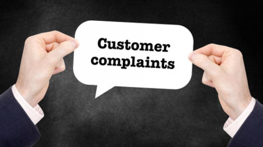 A person holding a sign with customer complaints