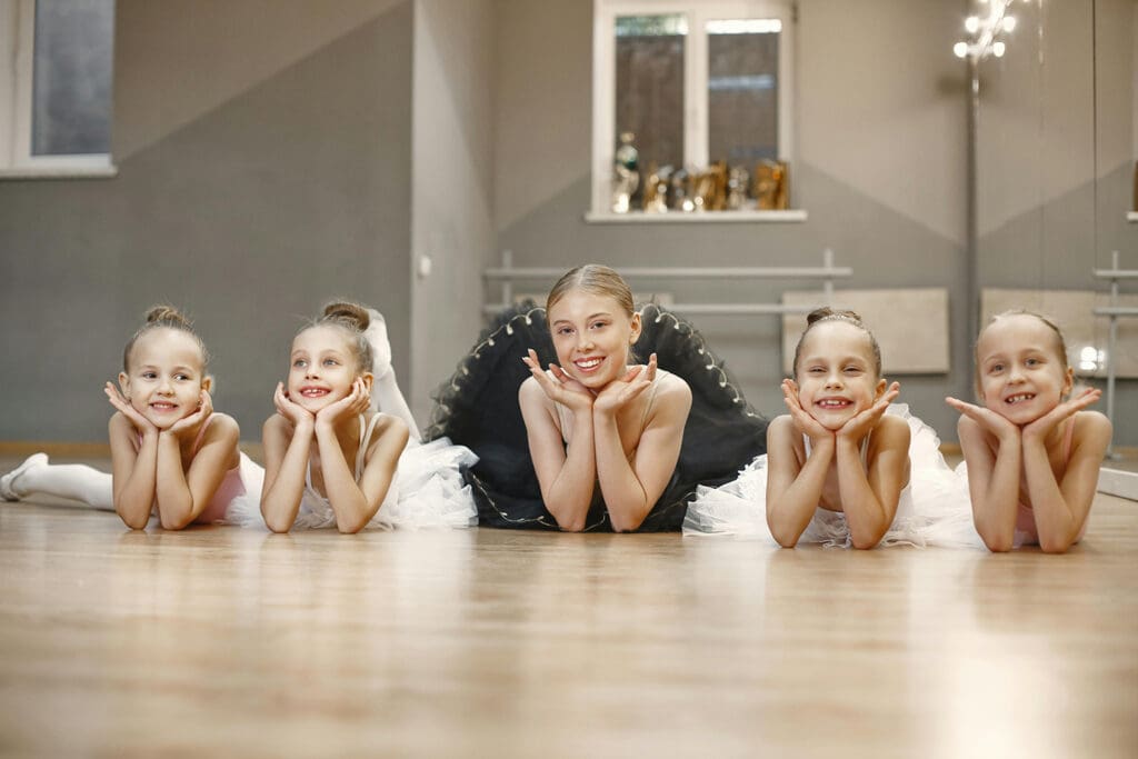 Smiling Ballet dancers on a wood floor