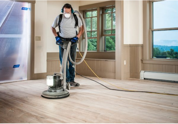 person shining up a hardwood floor with half-open windows
