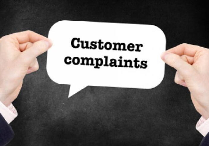 A person holding a sign with customer complaints